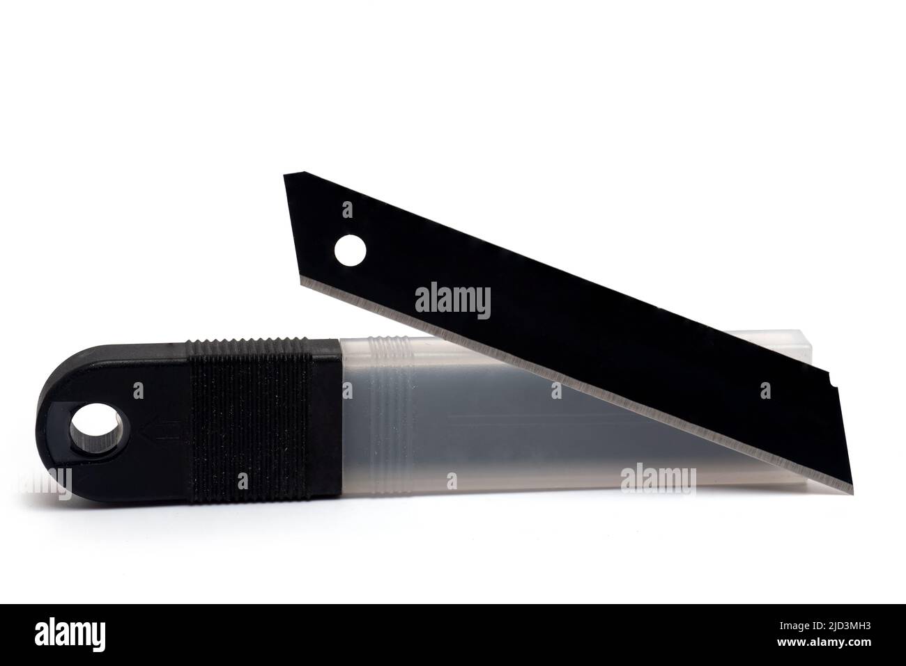 Close up of plastic package and dark sharp metal razor blade placed in front of it for use in knives with interchangeable snap off blades on white bac Stock Photo