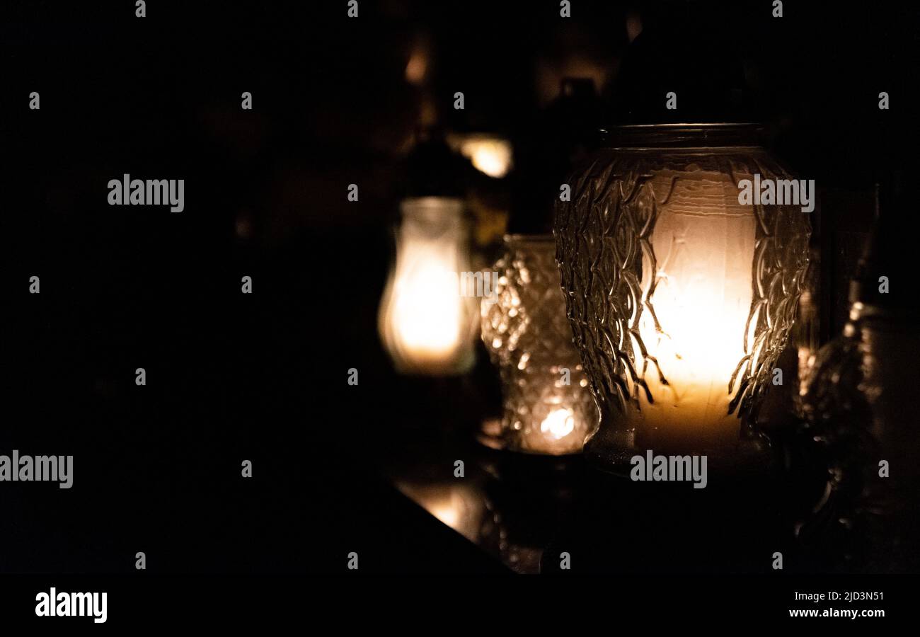 All Saints Day. Night at the cemetery. Candle flame at night on the