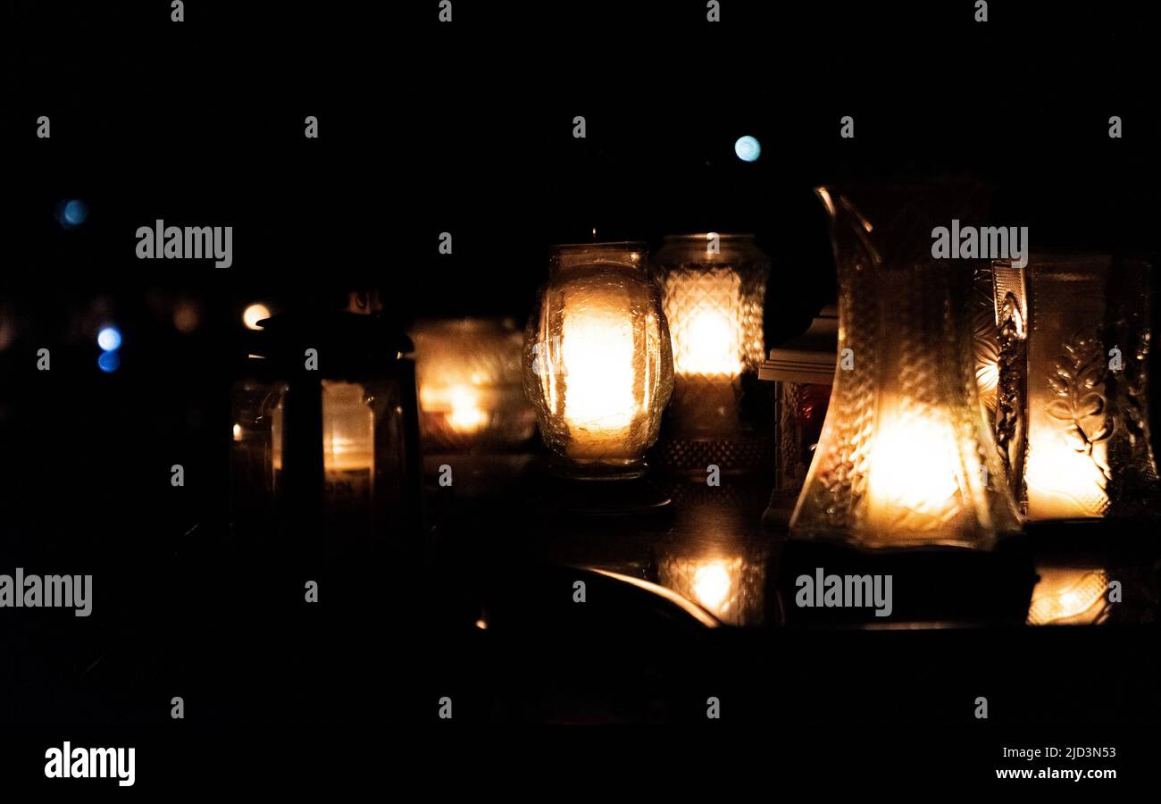 All Saints Day. Night at the cemetery. Candle flame at night on the