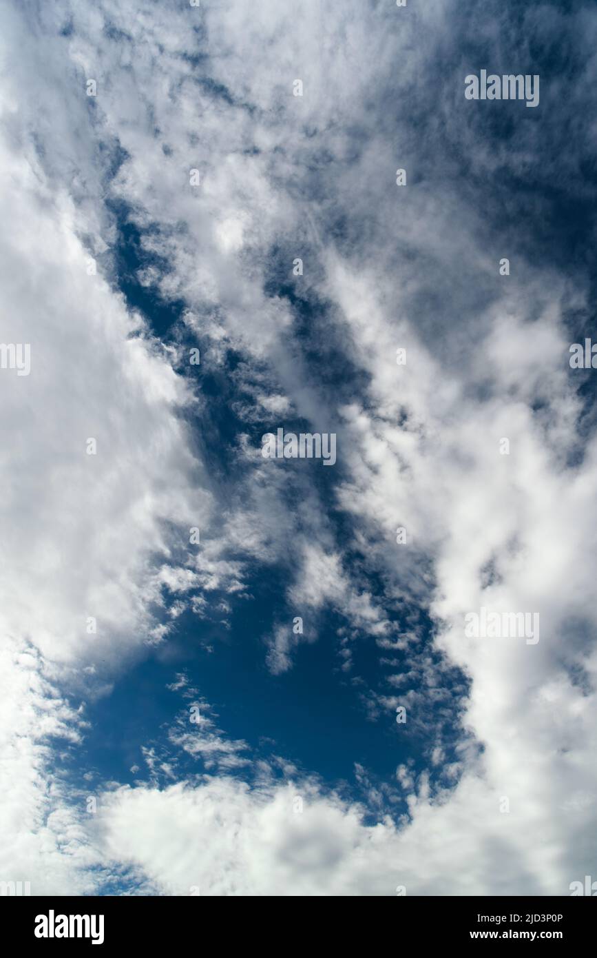 Blue sky with cumulus white clouds. Beautiful cloudscape. Abstract background. Vertical orientation Stock Photo