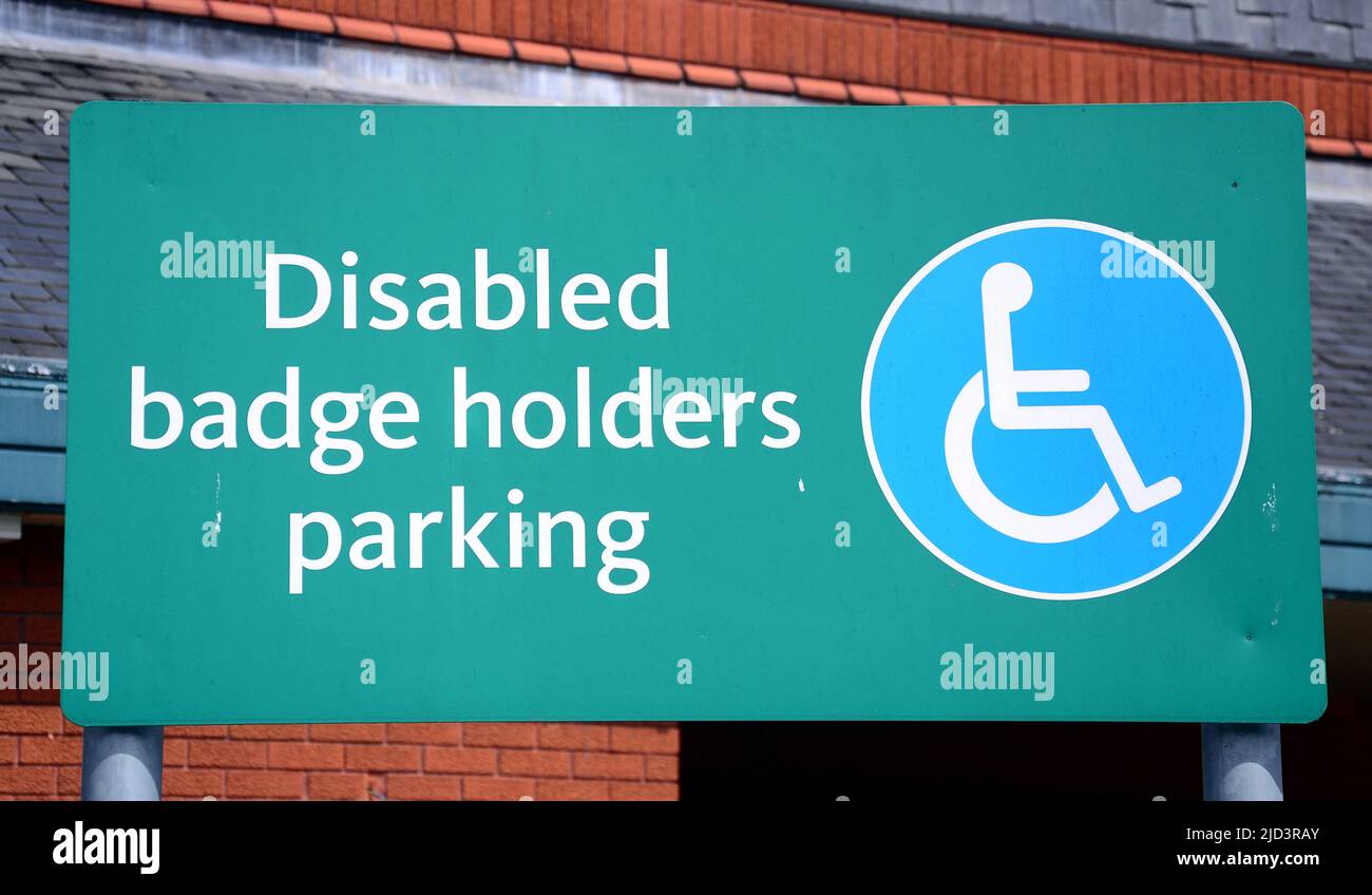 A disabled badge holders parking sign with a wheelchair symbol in