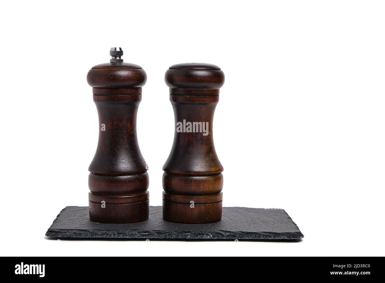 Pepper shaker and salt shaker on slate stone on white background Stock ...