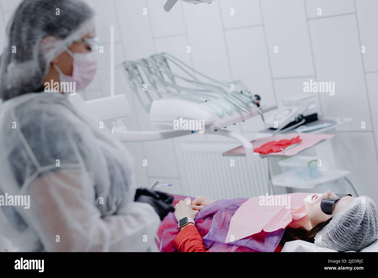 A female dentist in a dental office prepares a patient for treatment. High quality photo Stock Photo
