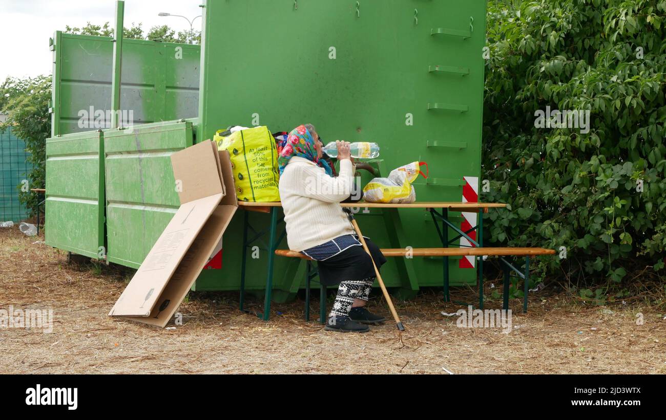 Immigrants refugees Ukraine detention Gypsies Gypsy waste container camp drinks from bottle people family grandmother stroller child Roma mother place Stock Photo