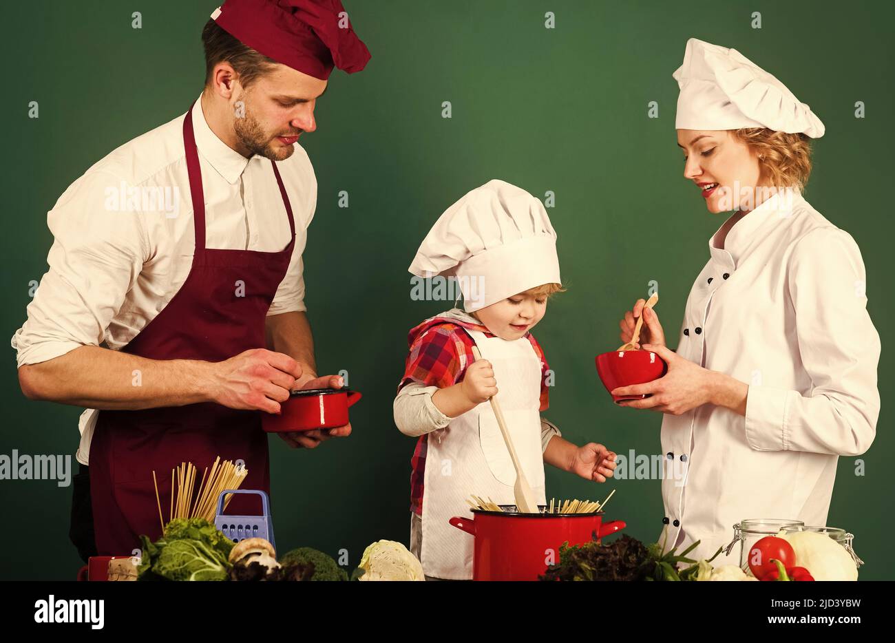 Family cooking at kitchen. Mother, father and son prepare tasty food. Healthy lifestyle. Advertise. Stock Photo