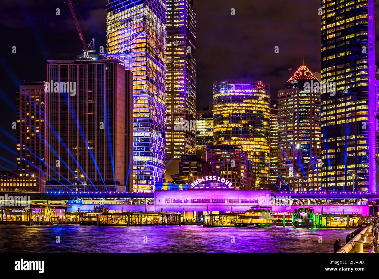 Circular quay ferry wharves on Sydney harbour at Vivid Sydney 2022 light show. Stock Photo