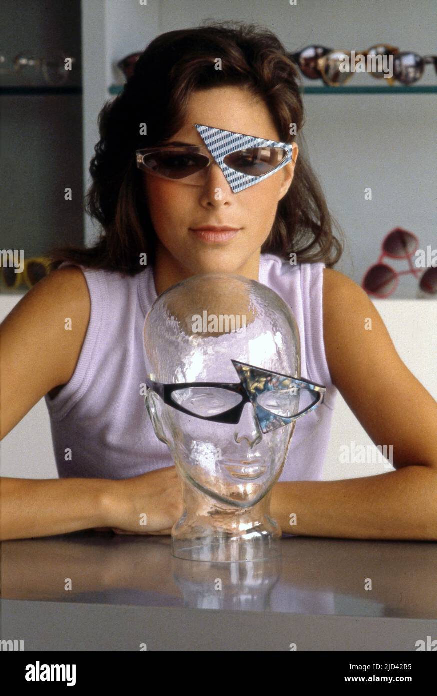 A woman poses in a pair of hip glasses at L.A. Eyeworks on Melrose Ave. in Los Angeles, CA, circa 1980s.gcndgn Stock Photo