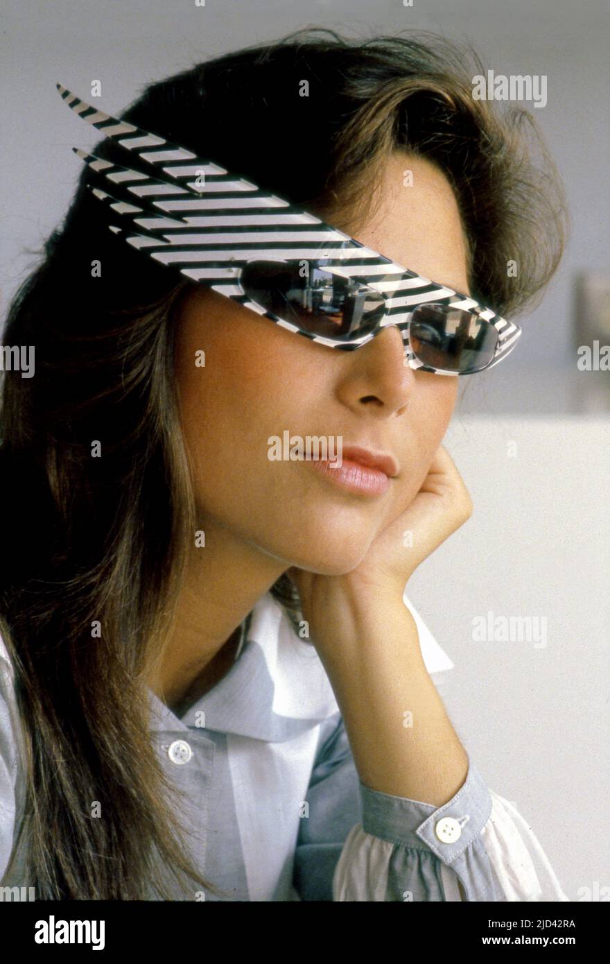 A woman poses in a pair of hip glasses at L.A. Eyeworks on Melrose Ave. in Los Angeles, CA, circa 1980s. Stock Photo