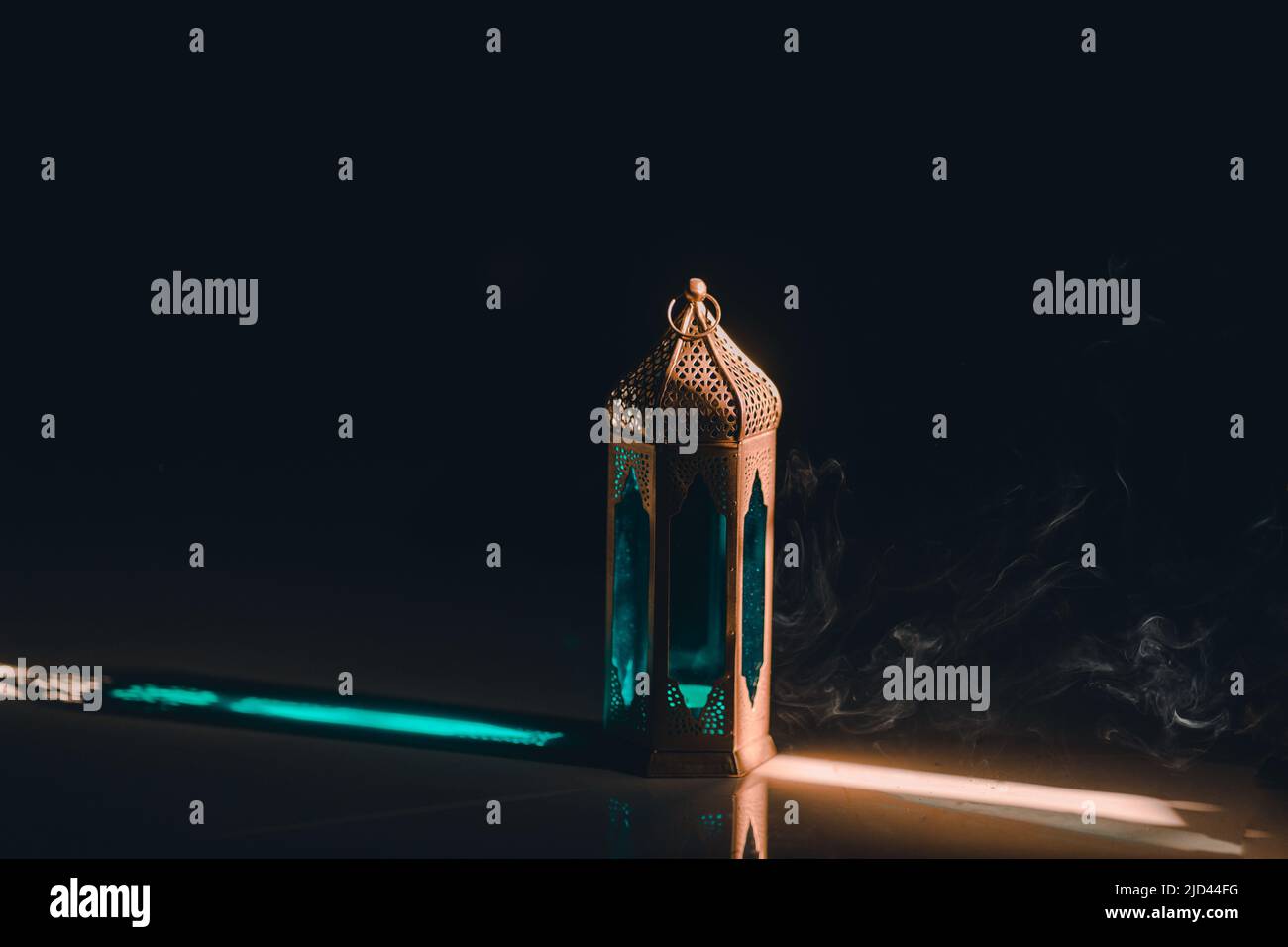 Ornamental Arabic lantern with a burning candle glowing at night