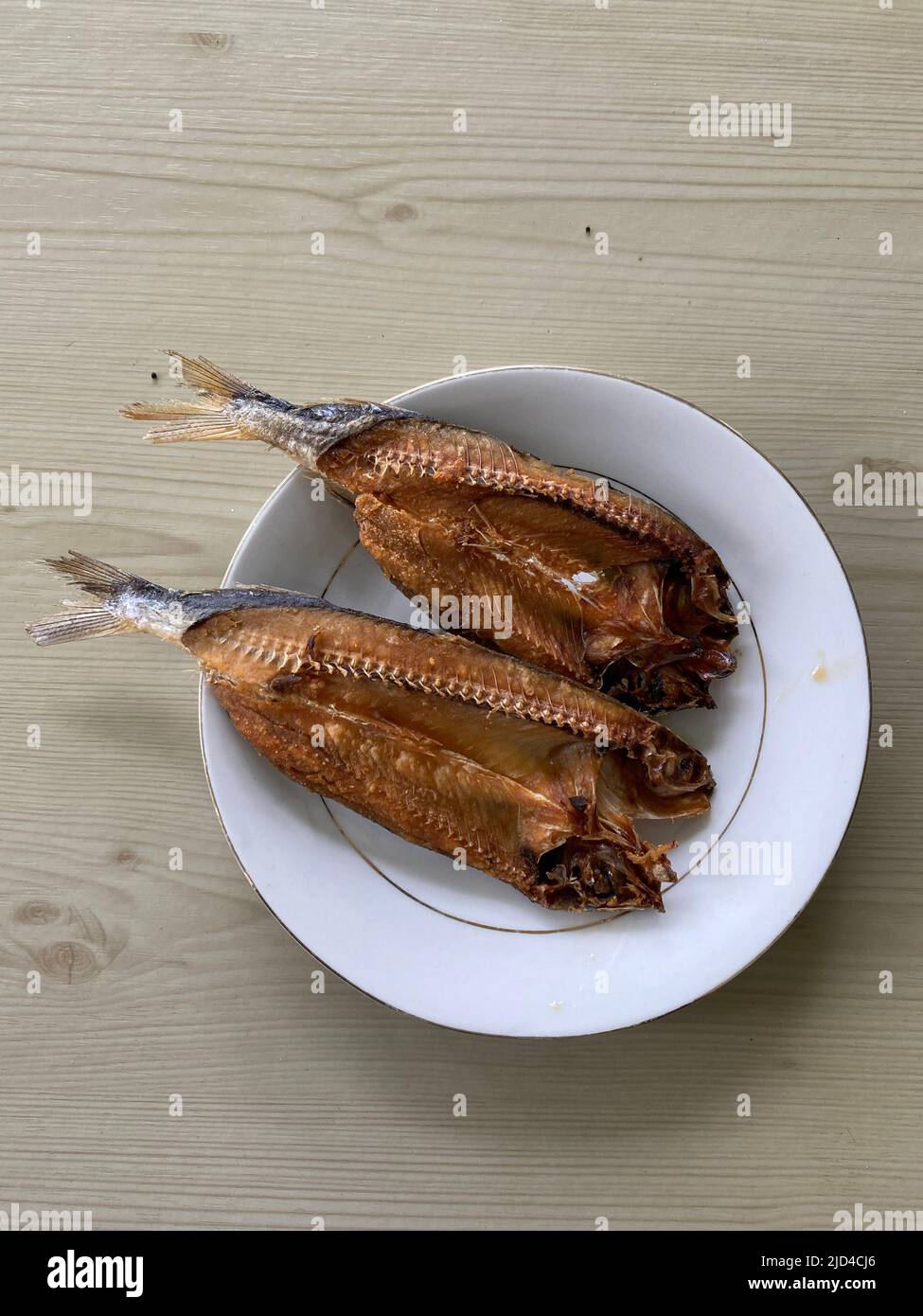 Photo of bangsi dried fish isdang lawin tuyo or cypselurus poecilopterus, yellow-wing flying fish served on a plate which is a native Filipino dish to Stock Photo