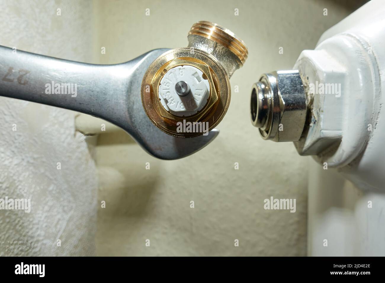 Stuttgart, Germany - February 01, 2022: Install Heimeier thermostat valve. Open-end wrench screws component to the old radiator. Modernize heating sys Stock Photo