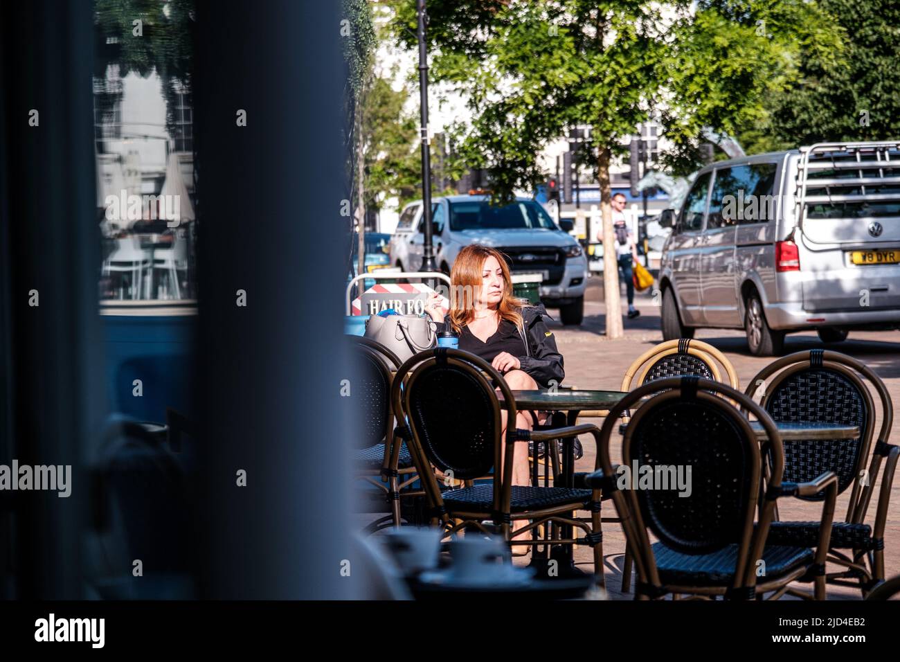 Epsom Surrey, London, June 11 2022, Woman With Red Hair Sitting Alone Outside Cafe Nero Relaxing Stock Photo