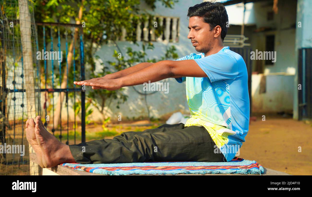 Athletic Rajasthani man in a sporty uniform engaged in yoga at outdoor. Yoga instructor, in outdoor exercise Stock Photo