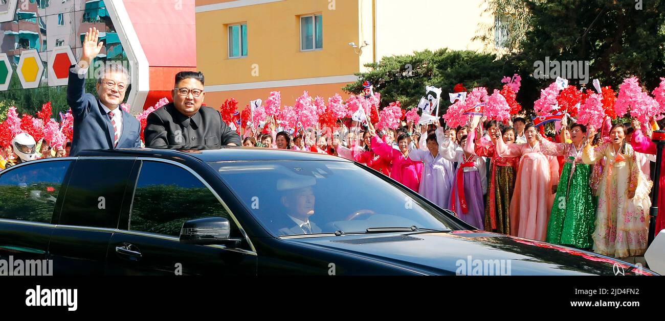 Sep 18, 2018-Pyeongyang, North Korea-South Korean President Moon Jae In and North Korean Leader Kim Jong Un Motorcade parade at Downtown in Pyeongyang, North Korea. The South and North Korean heads of state left Pyeongyang International Airport in separate limousines (as part of a motorcade), exiting their vehicles in front of the Three Revolutions Exhibition Hall to greet Pyeongyang citizens. They then got into the same open top limousine and proceeded in a car parade. After turning left at the Yongheung intersection, the two leaders traveled while waving to the Pyeongyang citizens lining the Stock Photo