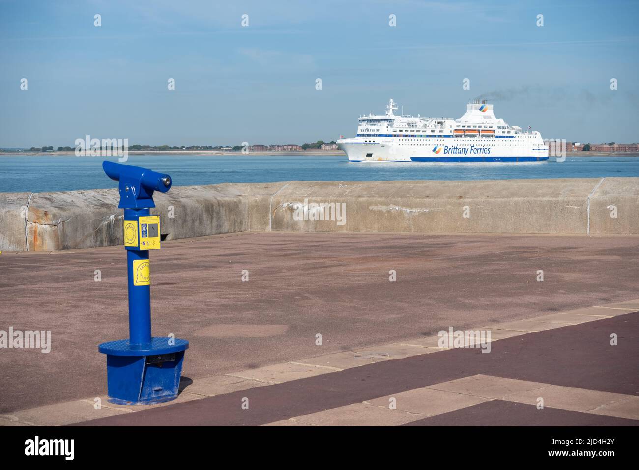 Normandie, one of Brittany Ferries ships leaving Portsmouth harbour, Southsea promenade in the foreground with a talking telescope. Stock Photo