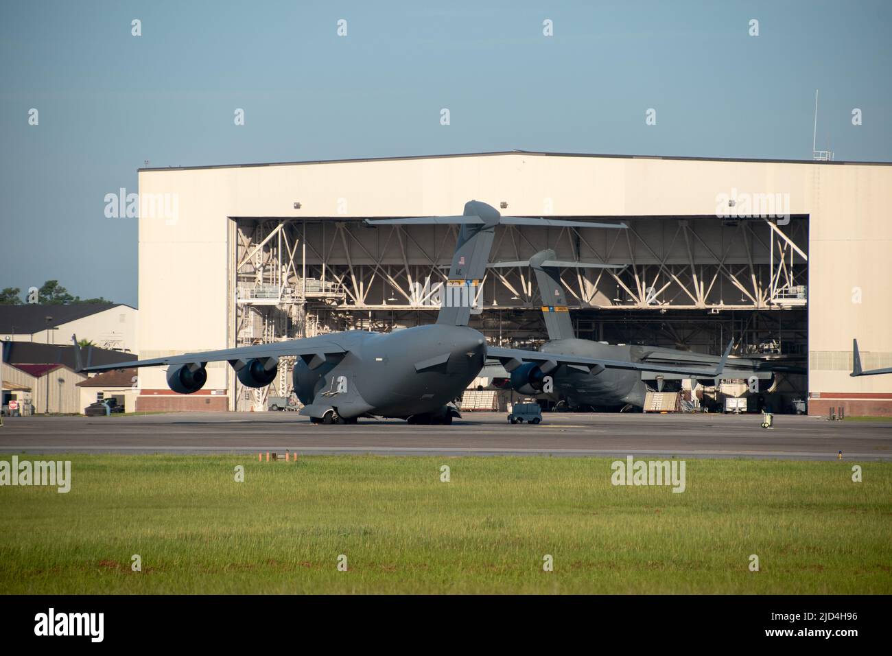 Two Boeing C-17 Globemasters parked at Charleston Air Force Base with one parked in a maintenance hangar Stock Photo