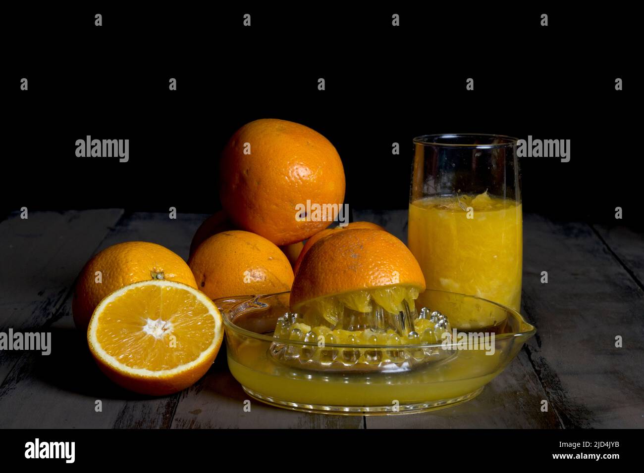 Orange juice squeezer with freshly squeezed juice in glass Stock Photo