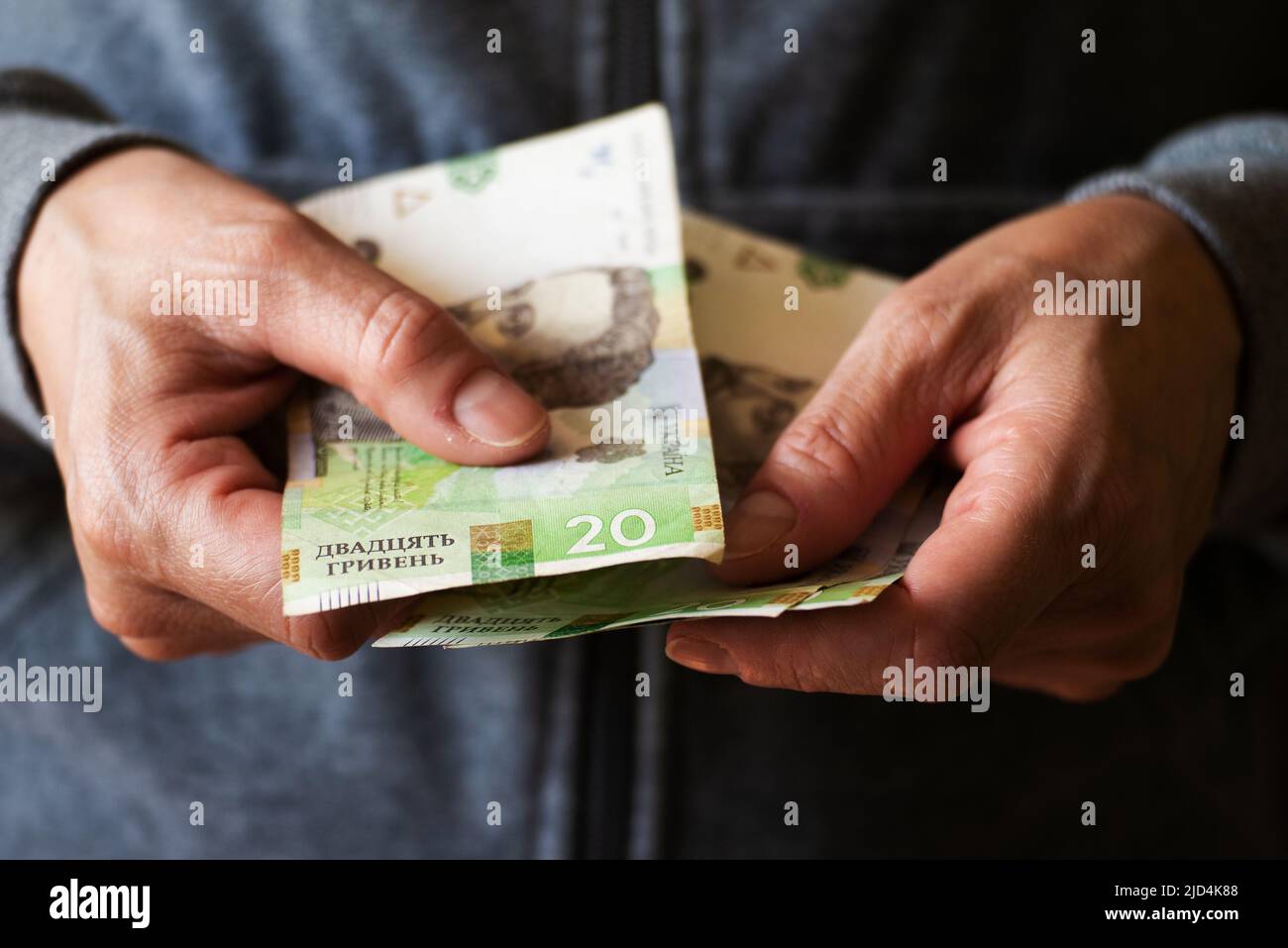 White woman giving Ukrainian money bills closeup Stock Photo