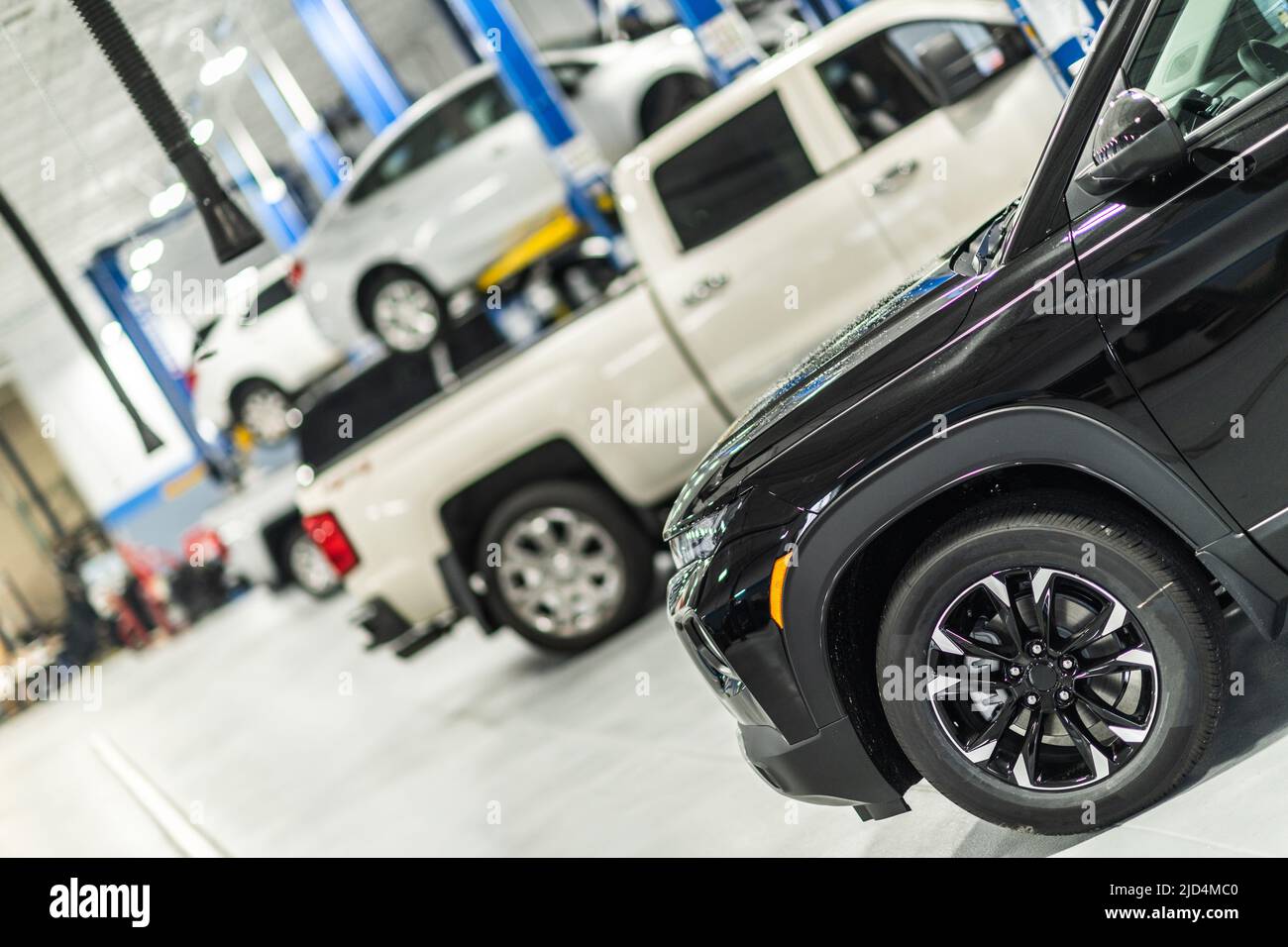 Professional Car Service and Detailing Facility Interior View. Cars Parked in a Line in a Queue for Maintenance and Repair Work. Work organization of Stock Photo