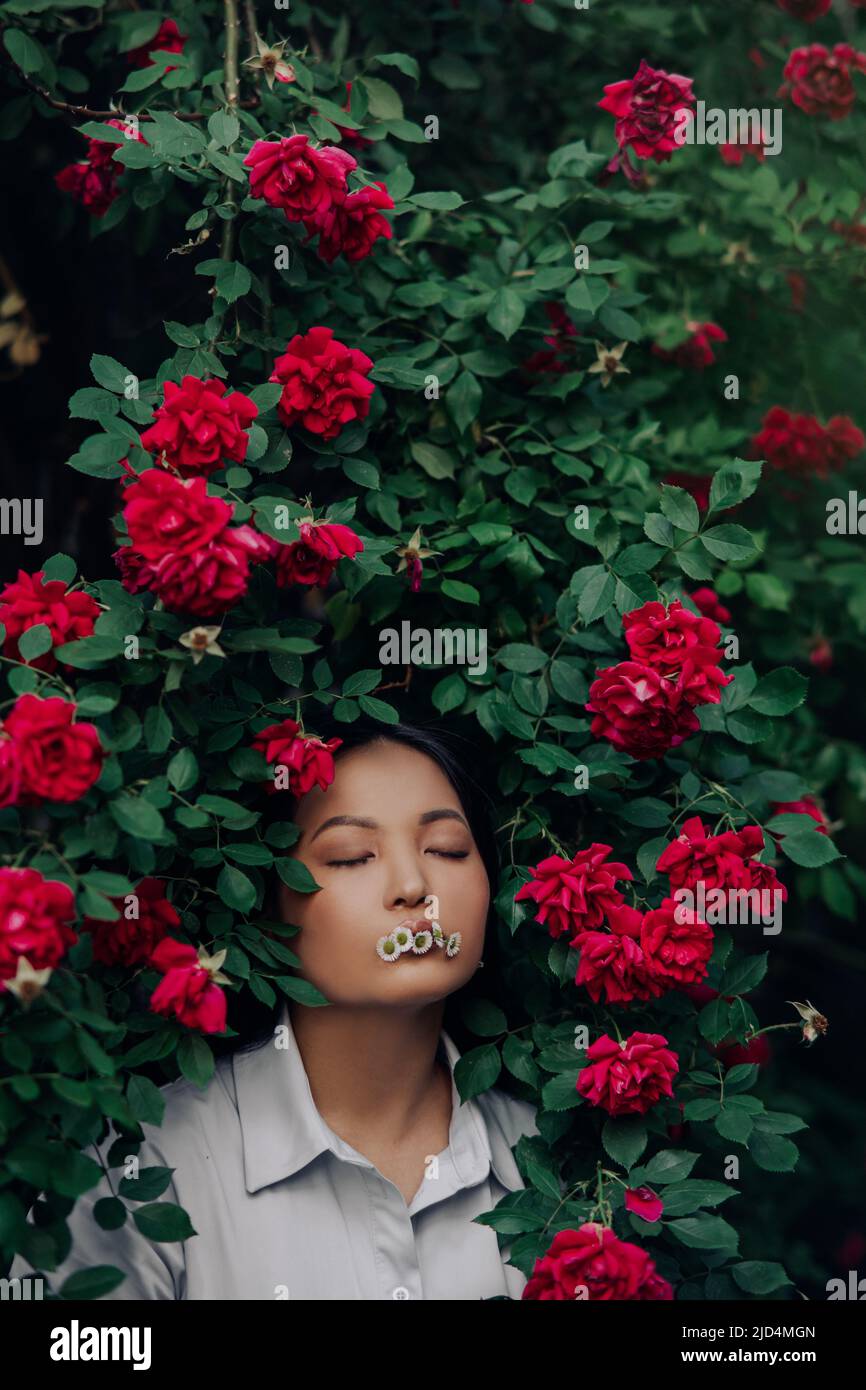 Portrait of young asian woman with closed eyes and chamomile flowers in ...