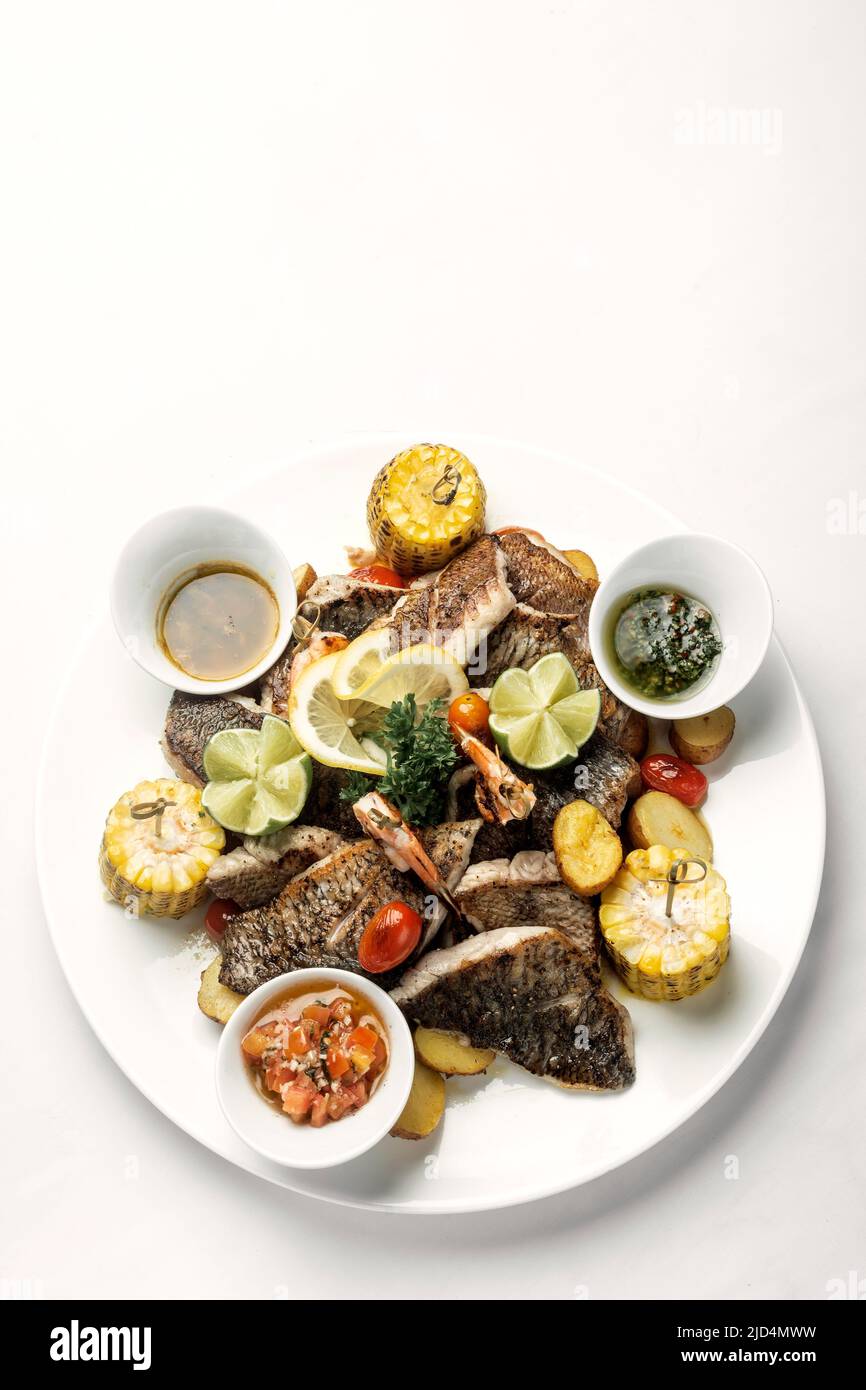 mixed fried fish plate with seared seabass and red snapper on white background Stock Photo