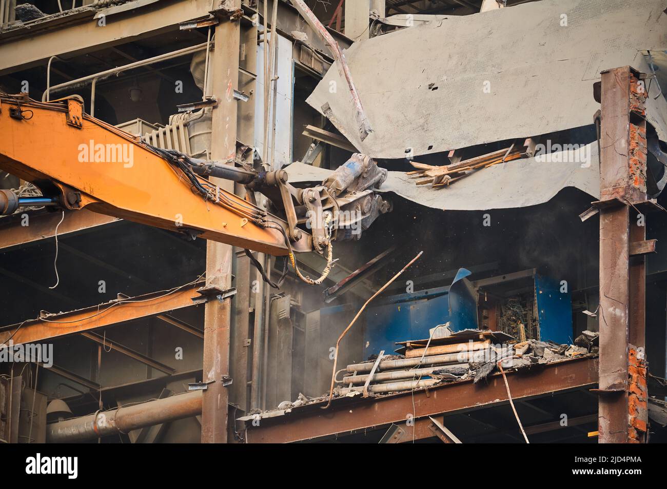 Hydraulic scissors on rigging demolish industrial building Stock Photo