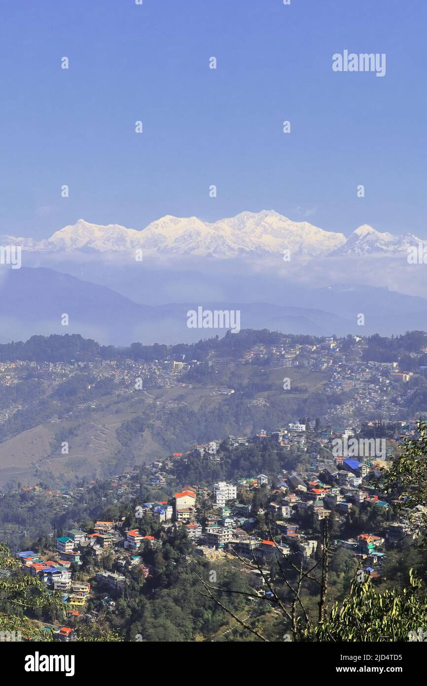 scenic view of darjeeling hill station and snowcapped himalaya mountains (sleeping buddha range), mount kangchenjunga against blue sky, in india Stock Photo