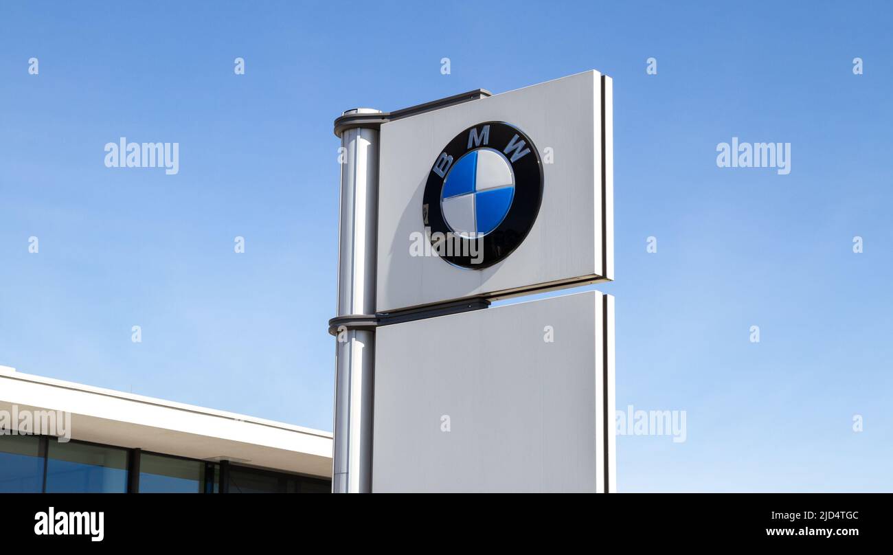 BMW car dealership forecourt pylon with logo sign. Bayerische Motoren Werke AG, luxury vehicles company. German manufacturer brand logotype signboard. Stock Photo