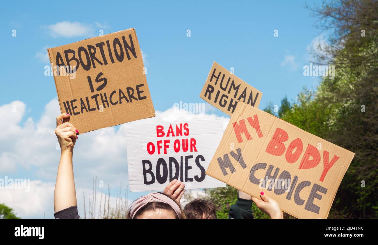 Protesters holding signs Abortion Is Healthcare, My Body My Choice, Bans Off Our Bodies, Human rights. People with placards at protest demonstration. Stock Photo
