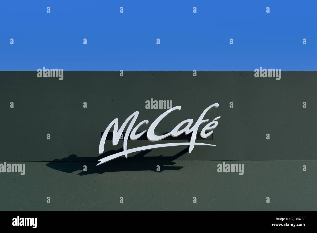 Savigliano, Italy - June 16, 2022: McCafe sign on McDonald's restaurant on blue sky. The McDonald's Corporation is world's largest chain of hamburger Stock Photo
