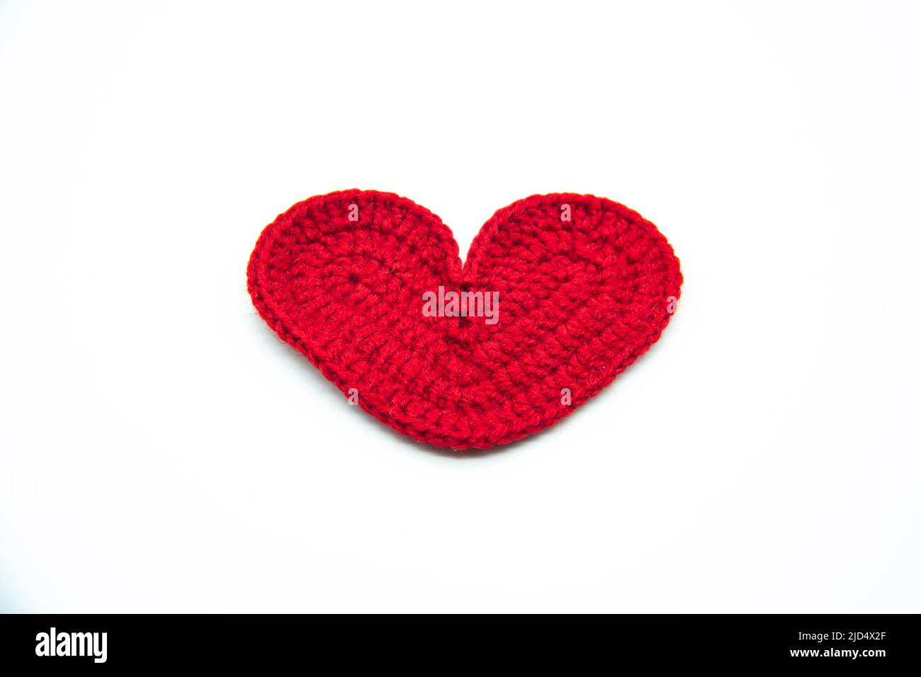 A red heart woven from red threads isolated on the white background Stock Photo