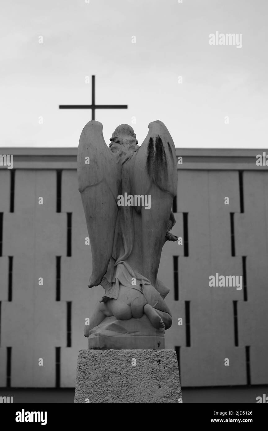 St Michael, the archangel, kneeling before God with his knees on Satan's head in black and white. Stock Photo