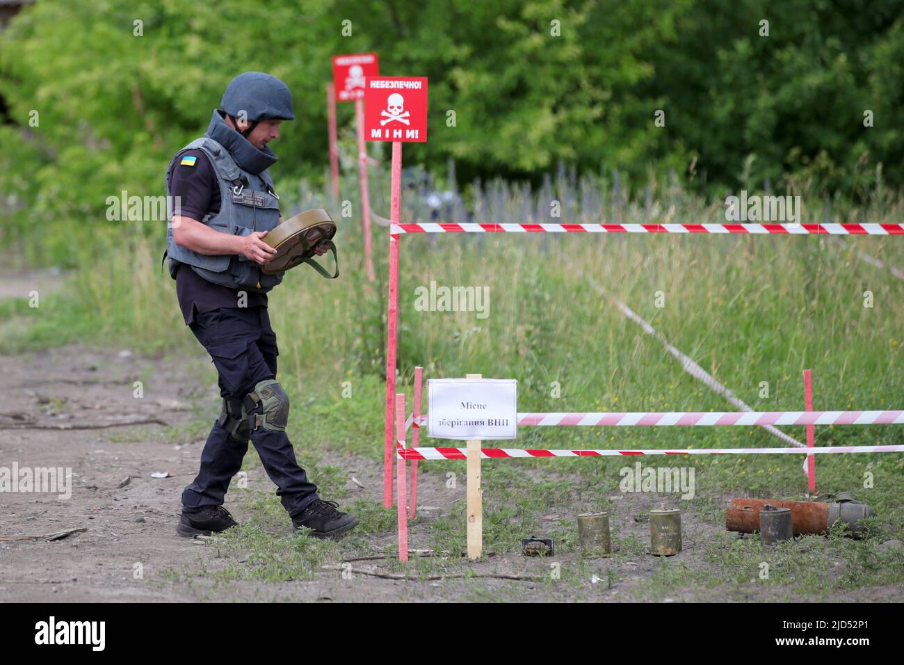 TROSTIANETS, UKRAINE - JUNE 17, 2022 - A rescuer carries a land mine on the premises of a brick plant where lots of ammunition and other explosive ite Stock Photo