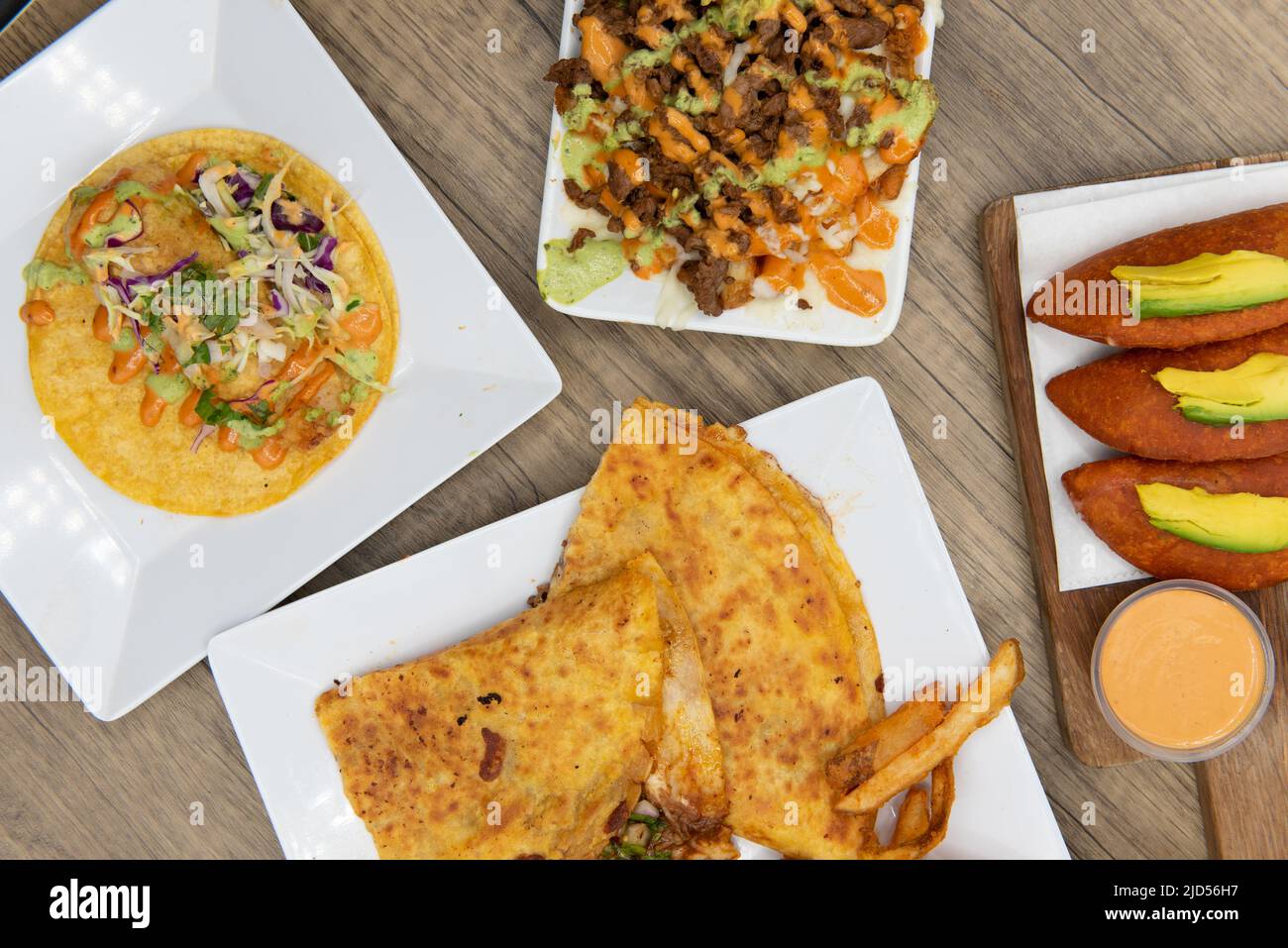 Overhead view of appetizing choices of quesadilla, taco, or asada fries for a tempting Mexican food delicacy. Stock Photo