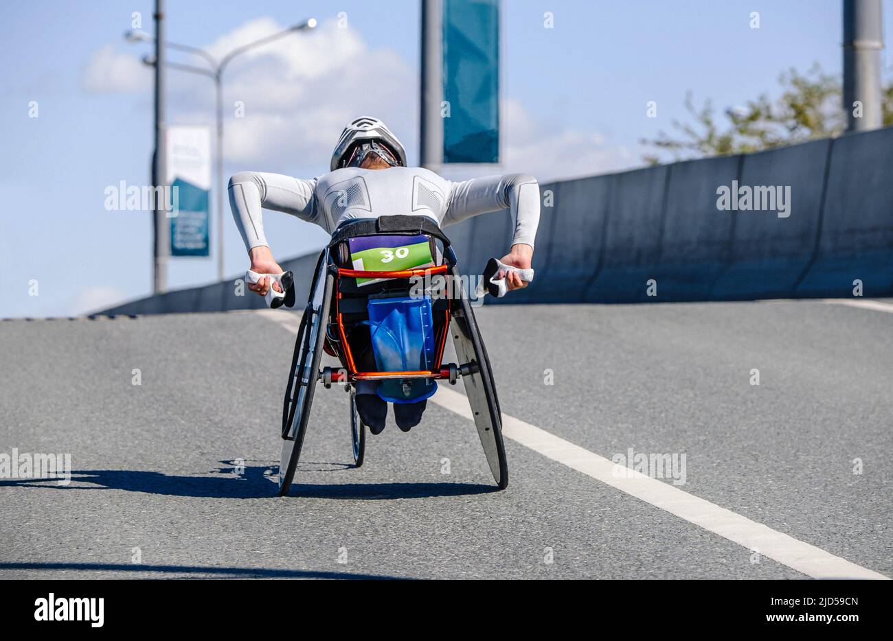 disabled athlete on racing wheelchair in marathon race Stock Photo