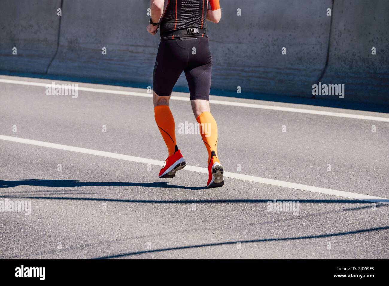 male athlete in compression socks running marathon Stock Photo