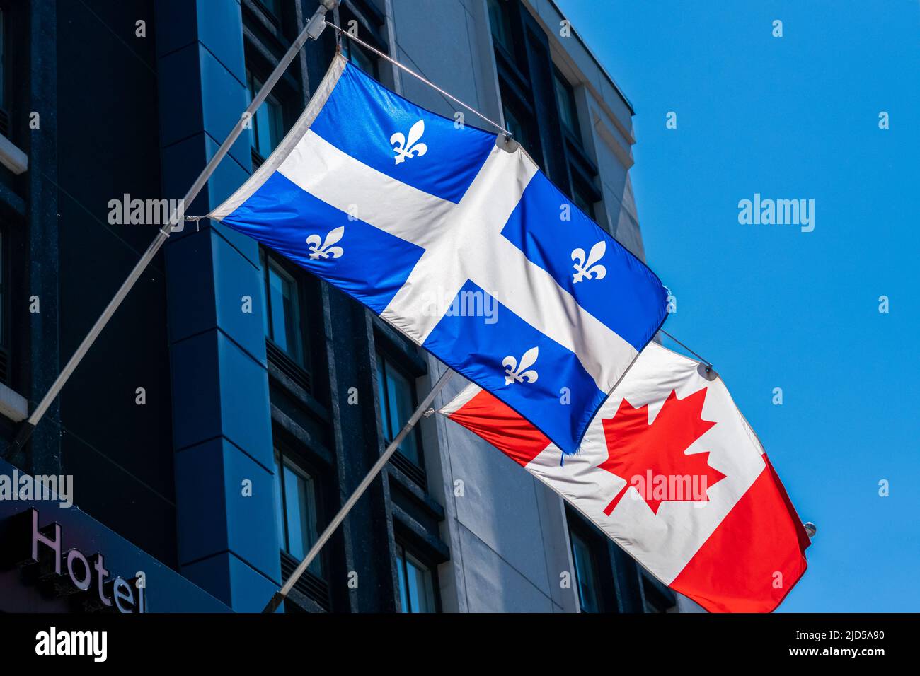 Canada and Quebec flags waving on a hotel facade Stock Photo