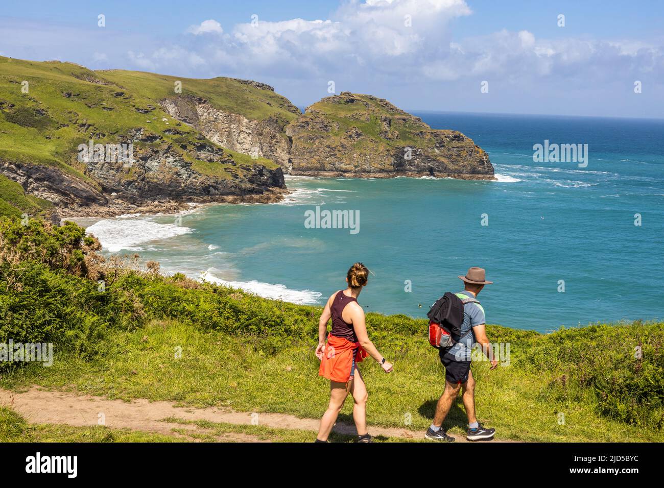 A couple enjoying hiking and the magnificent sea view from the southwest coast path close to Tintagel Cornwall England UK Stock Photo