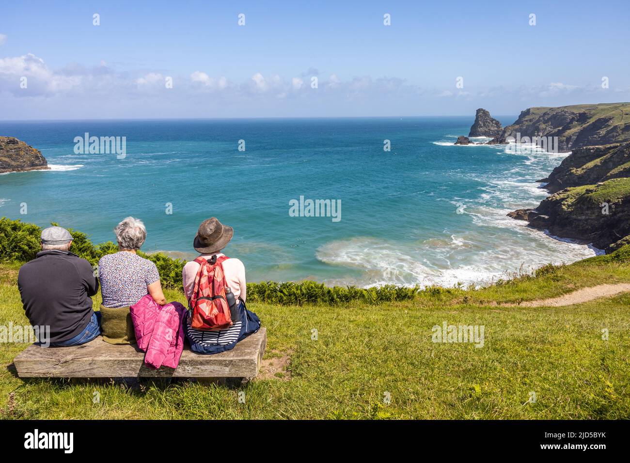 Friends enjoying a hiking rest stop and the magnificent sea view from the southwest coast path close to Trewethett Farm Tintagel Cornwall England Stock Photo