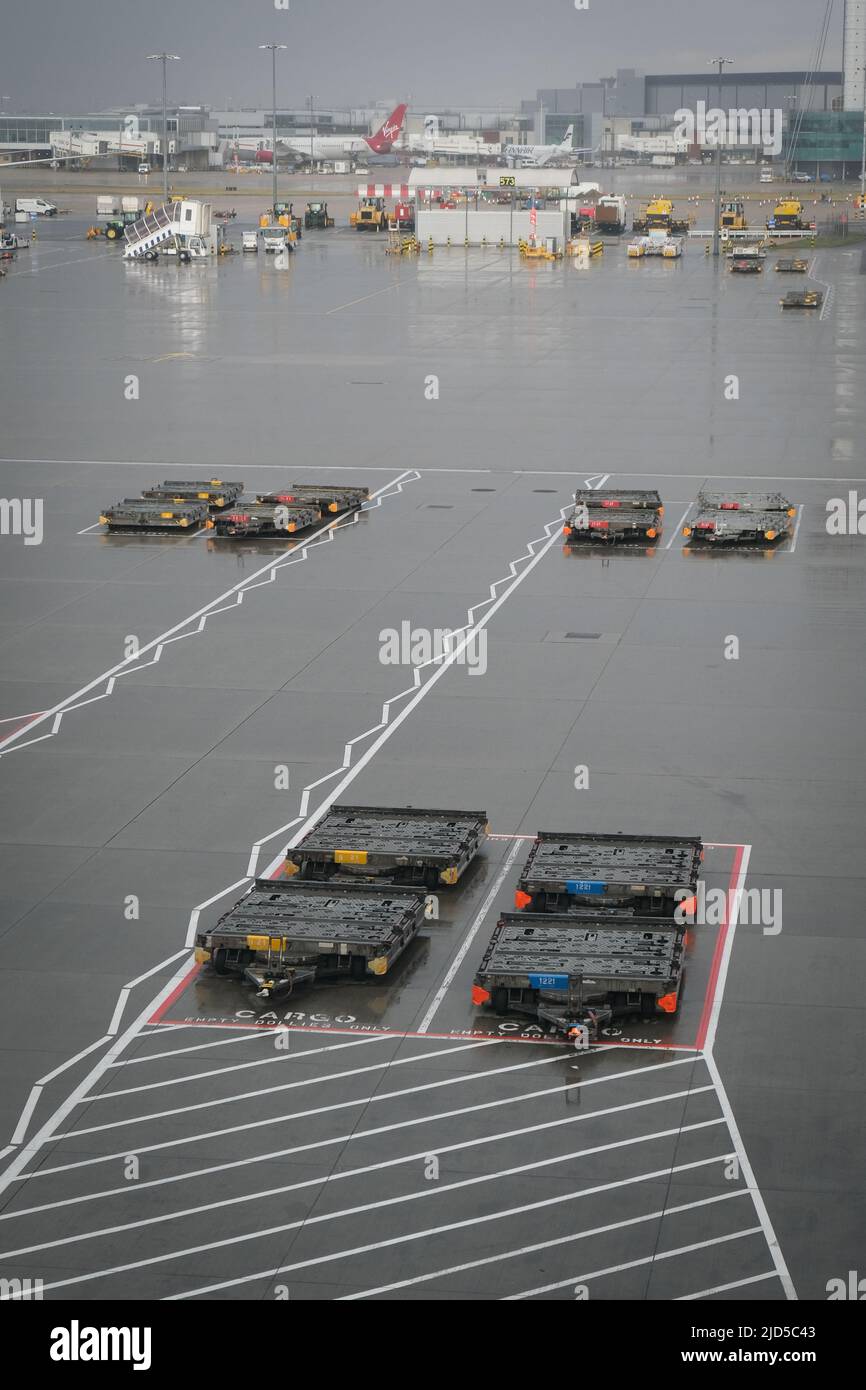 Cargo transportation vehicles parked on london Heathrow airport terminal. Stock Photo