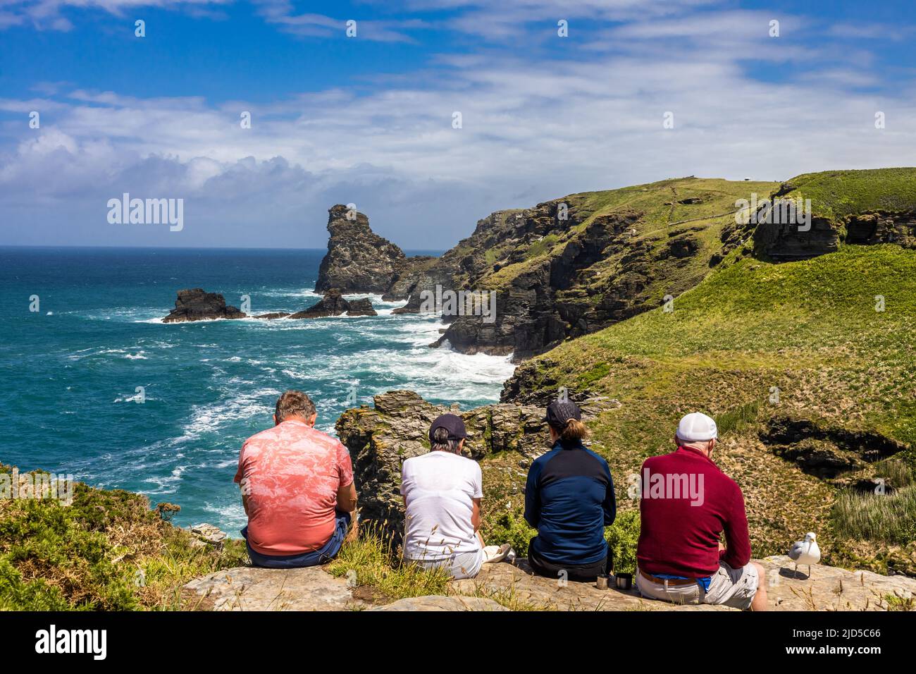 Two couples enjoying a hiking rest stop and the magnificent sea view from the southwest coast path close to Trewethett Farm Tintagel Cornwall England Stock Photo