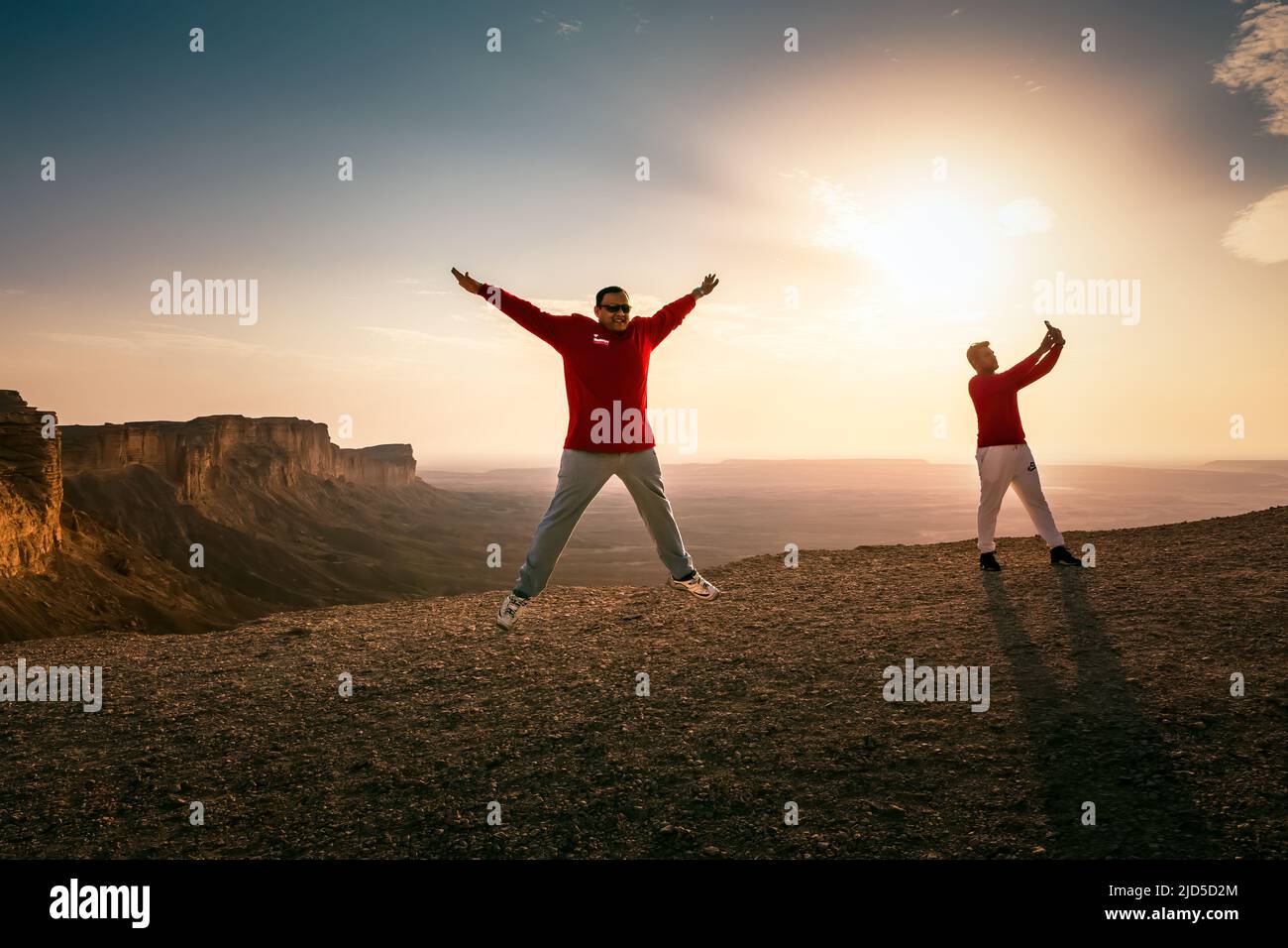 Happy Man jumping silhoutte poses with beautiful sunset background in Edge of the world Riyadh Saudi Arabia. Stock Photo