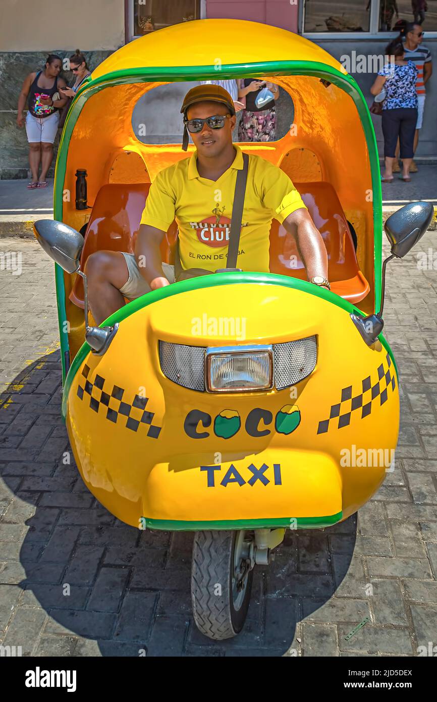 A so-called 'Coco Taxi' and its driver at Calle Obispo in Old Havana, Cuba Stock Photo