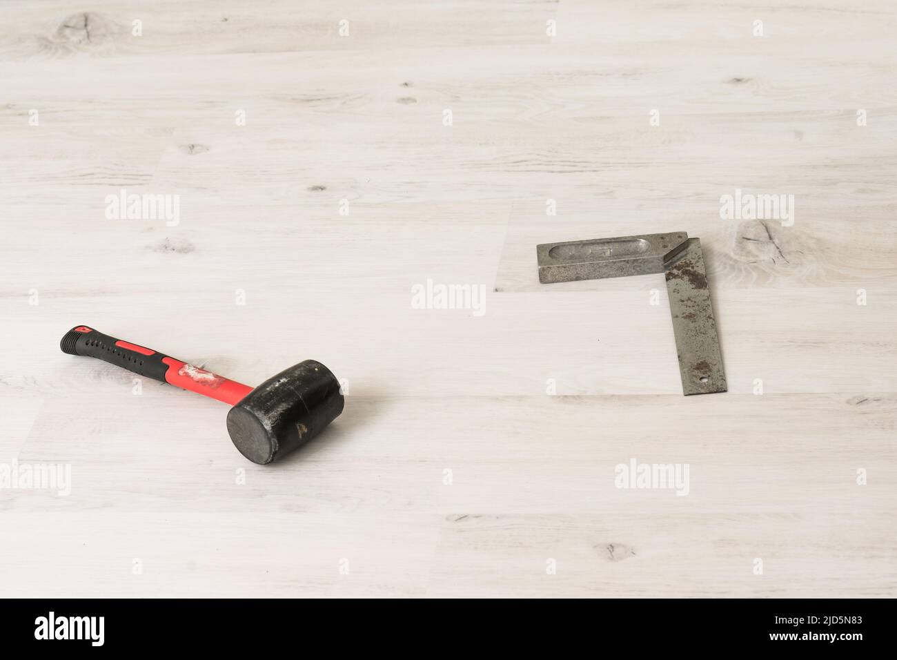 Rubber hammer and angle lie on the floor, working tools for floor ...