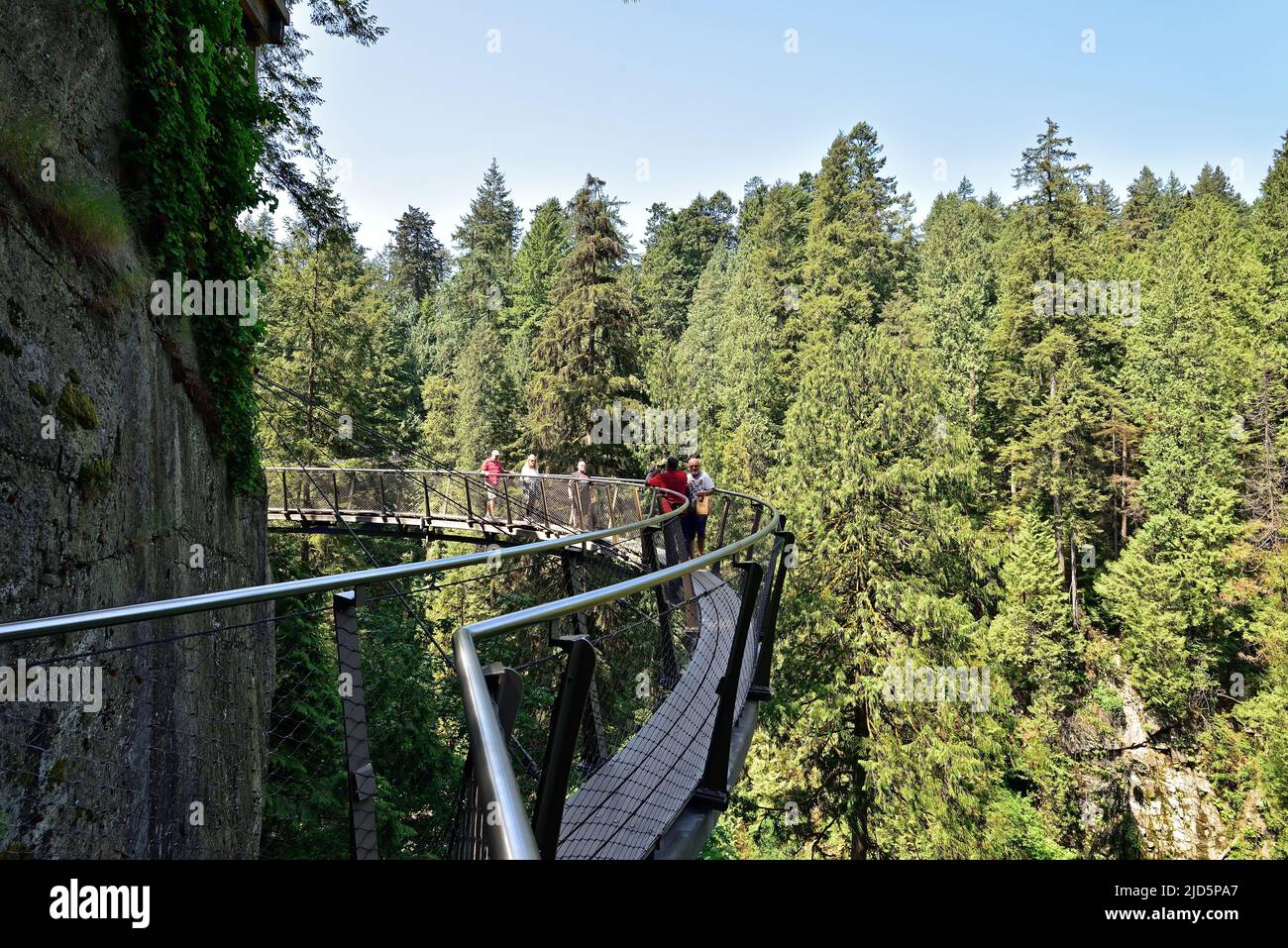 VANCOUVER, BRITISH COLUMBIA, CANADA, MAY 31, 2019: Visitors exploring the Capilano Cliff Walk through rainforest. The popular suspended walkways juts Stock Photo
