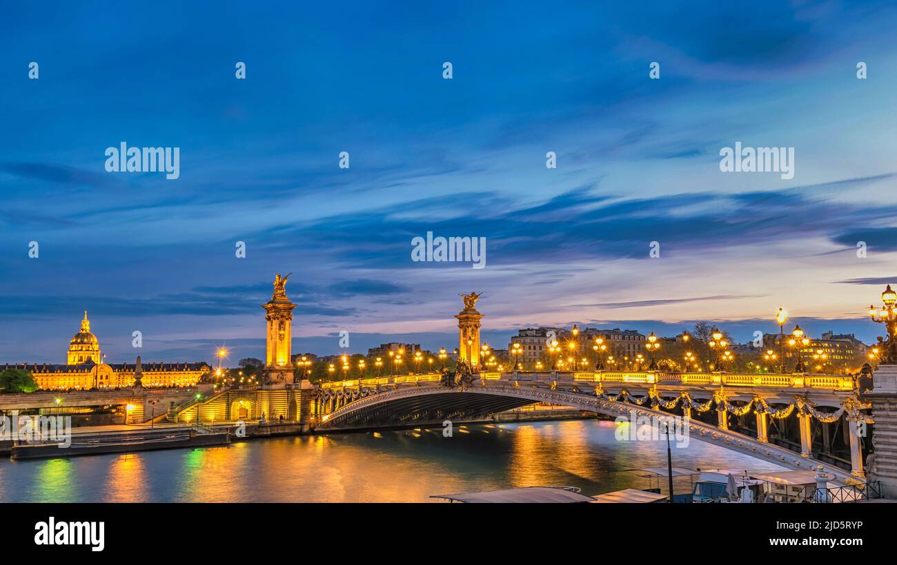 Paris France night city skyline at Seine River with Pont Alexandre III bridge Stock Photo