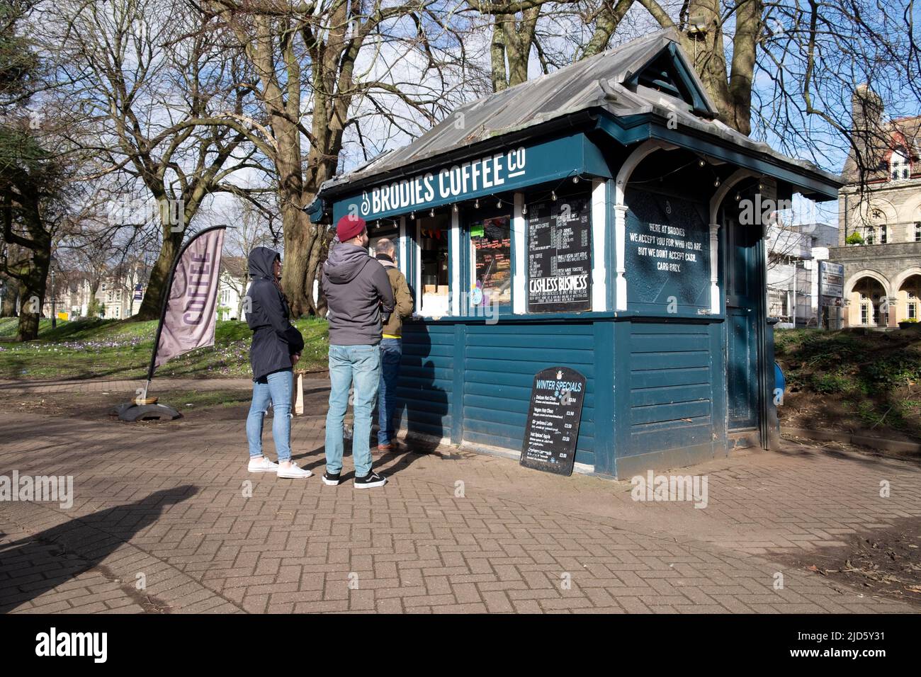 People couple customers queuing for hot drinks at Brodies Coffee Company shed kiosk in Bute Park Cardiff Wales UK KATHY DEWITT Stock Photo