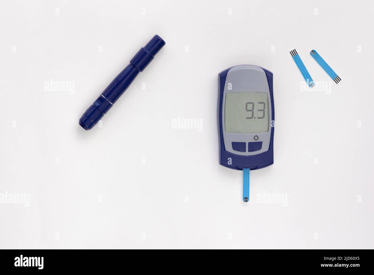 Top view of glucometer with nine point three 9.3 mmol per liter glycemic index on display with blooded test strip inside, lancet and test strips on wh Stock Photo