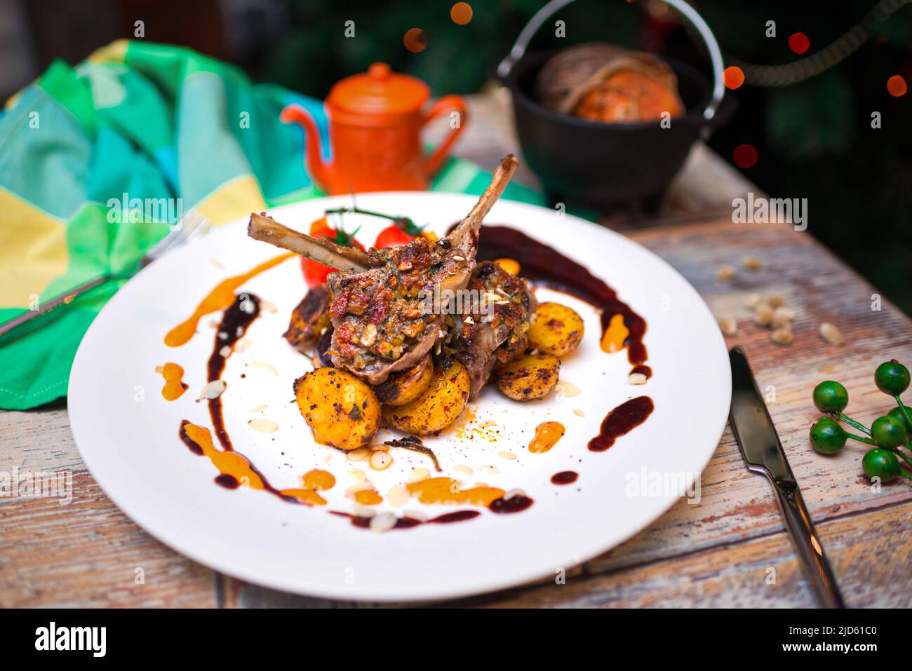 rack of lamb with baked mini potatoes on a plate covered in drops of souse Stock Photo