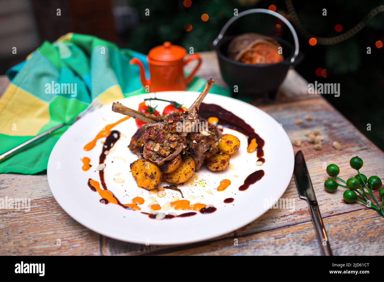 rack of lamb with baked mini potatoes on a plate covered in drops of souse Stock Photo